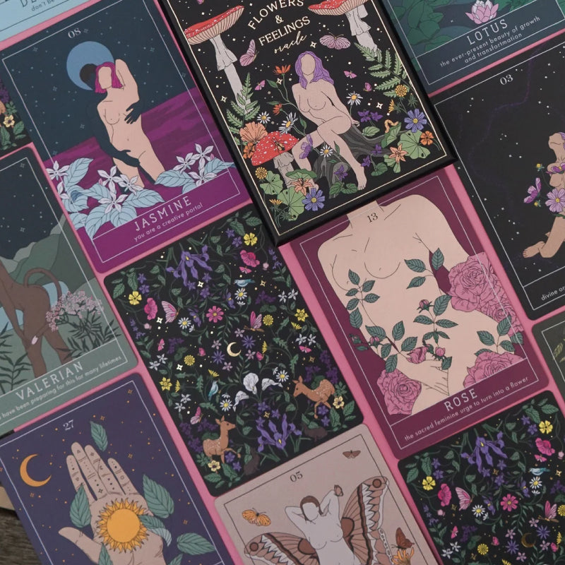 An arrangement of cards from the Flowers and Feelings Oracle Deck, such as Jasmine, Rose, and Valerian