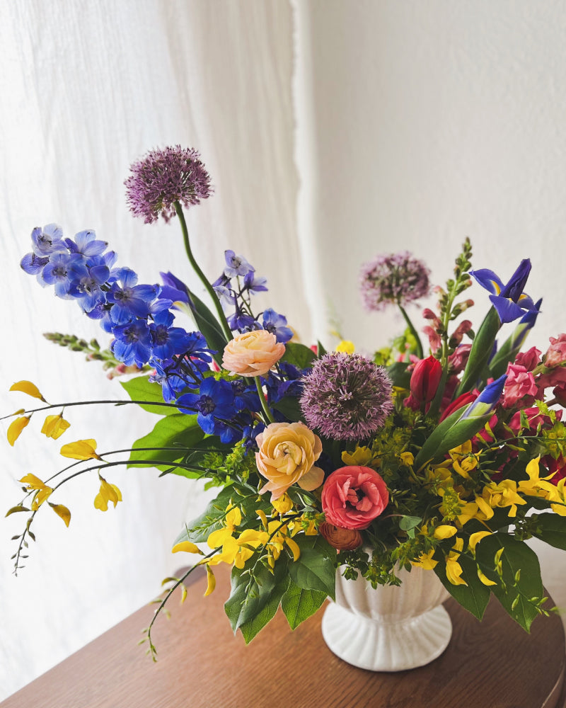 A vase arrangement featuring a rainbow of flowers