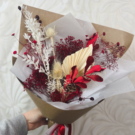 A red and white dried flower bouquet with a jasper crystal