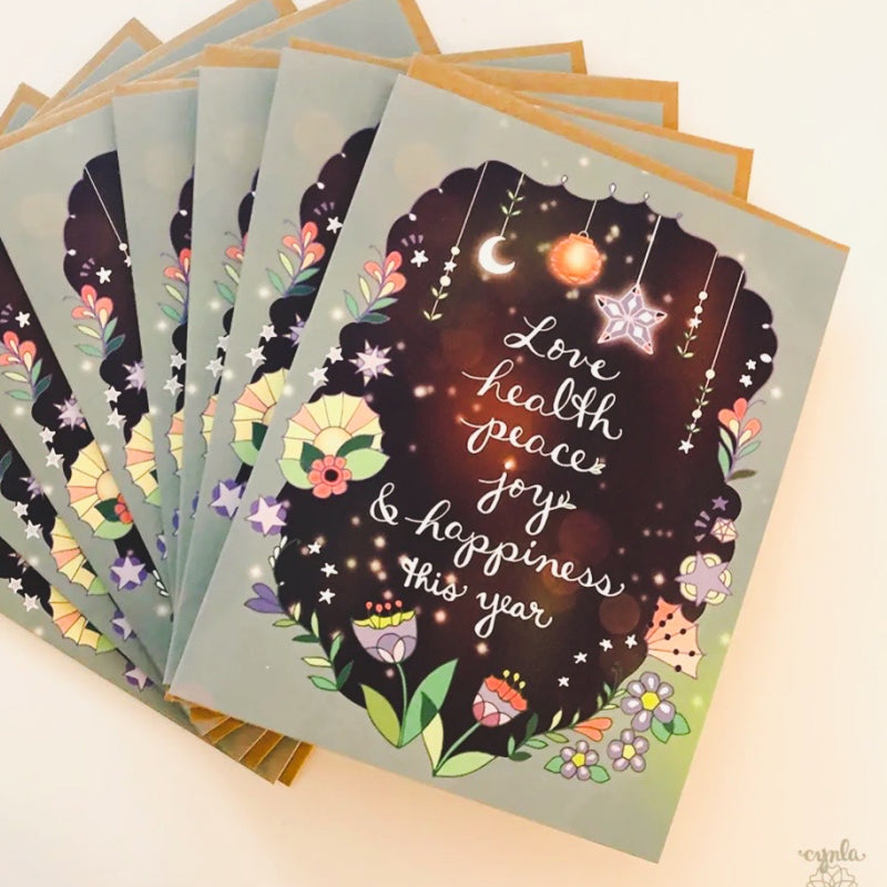 Holiday cards with stars and moons that say "Love Health Peace Joy and Happiness this Year"