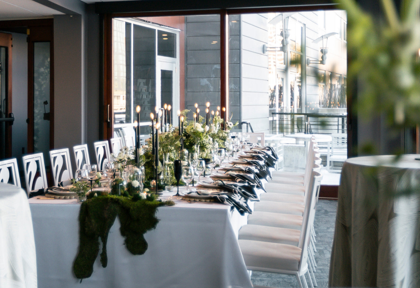 A long table for 18 with a table scape of greenery, florals, and moss down the middle