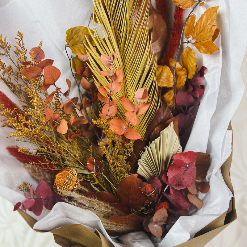 An up close image of an abundant dried flower bouquet featuring real carnelian crystals