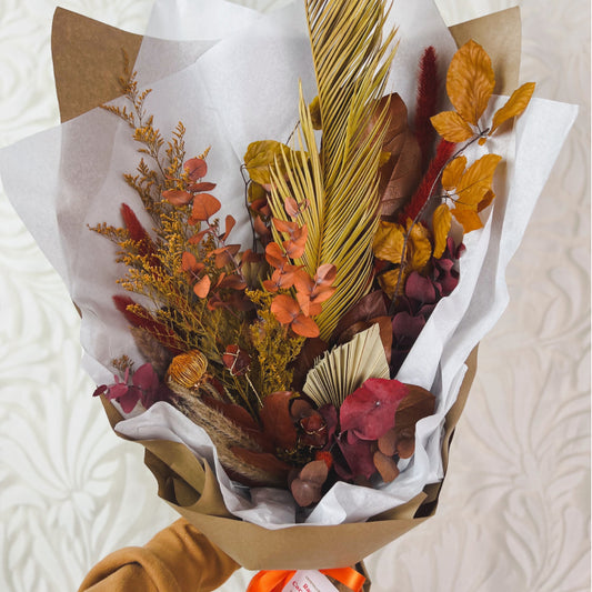 Dried flower and crystal bouquet featuring carnelian and flowers in shades of orange, rust, red, and brown