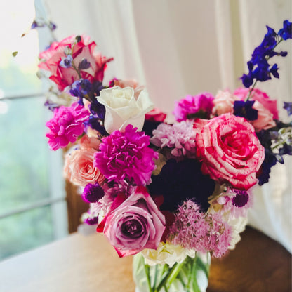 A flower arrangement featuring lots of pink and purple flowers