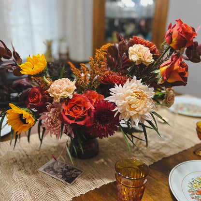 An abundant autumn centerpiece on a table set for Thanksgiving with the ten of pentacles tarot card