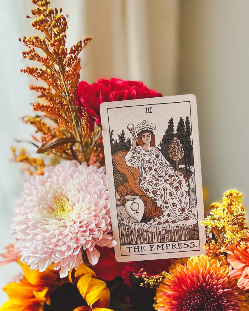 The Empress tarot card sitting on a flower arrangement