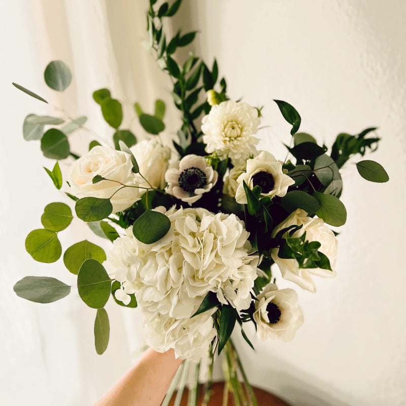 Small flower bouquet featuring white flowers and eucalyptus