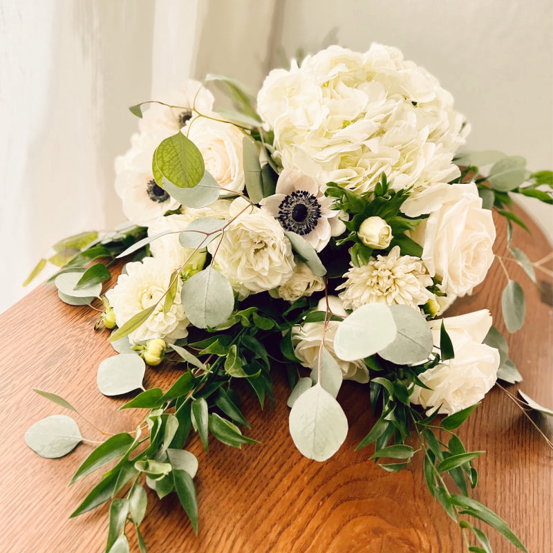Bouquet of premium white flowers and greenery laying on its side