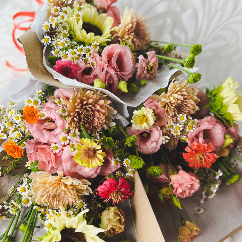 A trio of bright & colorful designer's choice bouquets wrapped and ready for delivery