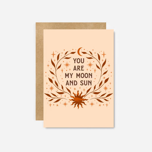Orange greeting card that says "You are my moon and sun" with illustrations of both